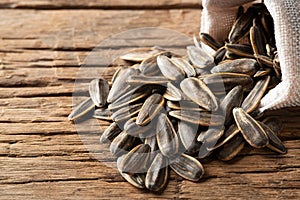 Heap of Dried sunflower seeds in the sack on wood plate