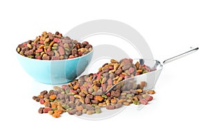 Heap of dry pet food in metal scoop and plastic bowl