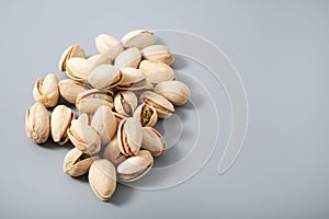 Heap of fresh pistachio nuts, snack for vegan or vegetarian, gray background with copy space