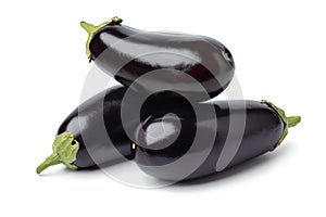 Heap of fresh whole purple eggplants on white background close up