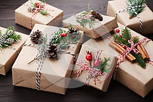 Heap of gift or present box wrapped in kraft paper with christmas decoration on rustic wooden background.