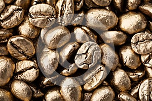 Heap of golden coffee beans textured as background