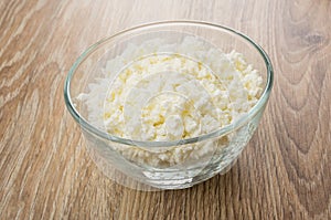 Heap of grained defatted cottage cheese in transparent glass bow