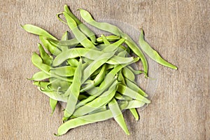 Heap green beans on wooden background.