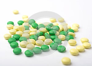 A heap of green and yellow medicine pills.