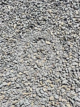 Heap of grey dry round stones background, top view.