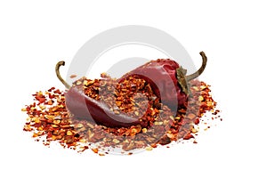 Heap of ground dried chili pepper flakes and pods on white background, full depth of field