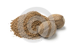 Heap of ground nutmeg and whole nutmeg seeds