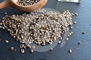 A heap of hemp seeds on the black stone background