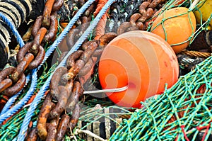 A heap, a huddle of traditional fishing equipement with green nets and orange buoys