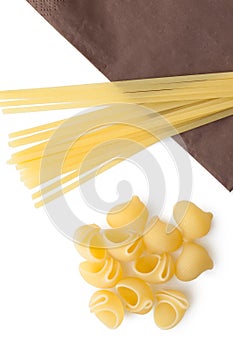 Heap of italian macaroni shells and spaghetti/pasta on napkin.