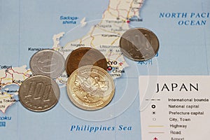 Heap of Japanese Yen coin money put on the Japan map. Concept of finance or travel