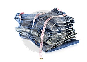 Heap of jeans trousers with tape measure