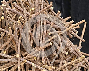 Heap of licorice roots on black fabric background.