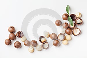 Heap of macadamia nuts on white table top view.