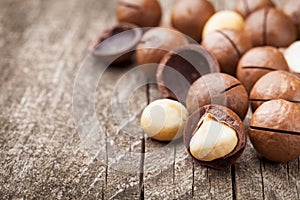 Heap of macadamia nuts on wooden rustic table.