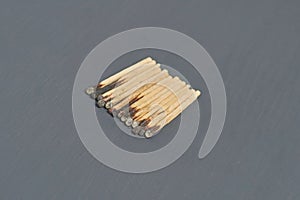 Heap of many used matchsticks with burnt sulfur on dark concrete table on kitchen