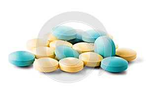Heap of medical pills in yellow and green color, with shadows on isolated white background. Pills with round shape.