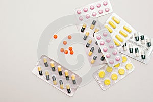 Heap of medical pills in yellow, pink and green colors. Pills in plastic package.