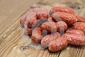 Heap of mini Salamis on wooden background