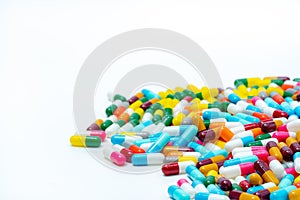 Heap of multi-colored antibiotic capsule pills on white background. Antibiotic drug resistance. Antimicrobial drugs.