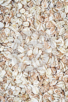 Heap of oat flakes, texture of uncooked flake. Diet food concept. Background of raw oatmeal. Carbohydrates product