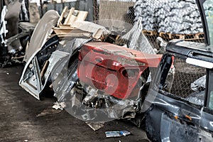 Heap of old rusty disassembled car parts at workshop waste storage hangar indoor. Vehicle salvage dismantling garage