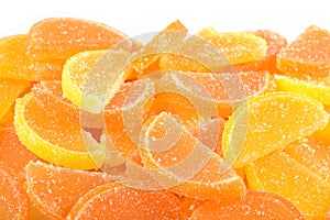 Heap of orange and lemon candy slices on a white