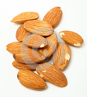Heap of organic almond nuts on white background. Shallow dof.