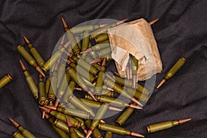 Heap and packaging of rifle cartridges on black textile surface
