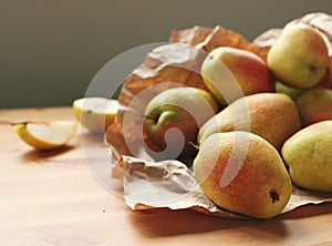 Heap of pears on wooden table rapped in paper