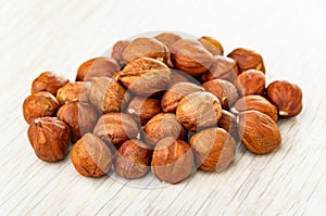 Heap of peeled hazelnuts on wooden table