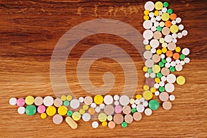 Heap of pills on wooden desk