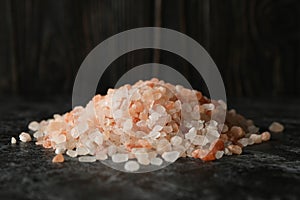 Heap of pink himalayan salt on black smokey table
