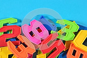 Heap of plastic colored numbers on a blue background