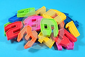 Heap of plastic colored numbers on a blue background