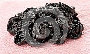 Heap of prune on pink paper napkin