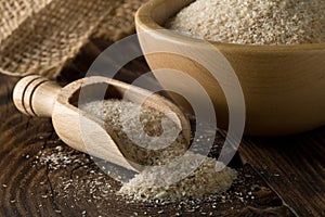 Heap of psyllium husk also called isabgol in wooden scoop and bowl on table