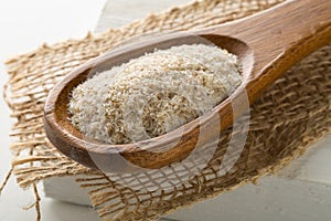 Heap of psyllium husk also called isabgol in wooden spoon on burlap