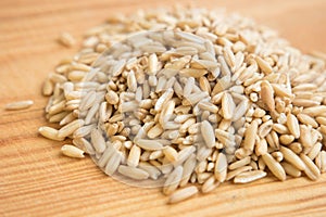 heap raw oats in wooden background.