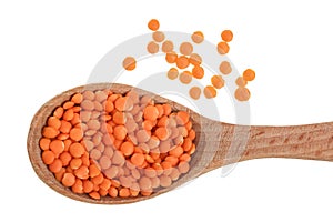 Heap of raw red lentils in wooden spoon isolated on white background