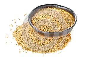 Heap of raw, unprocessed mustard seed kernels in bowl on white photo