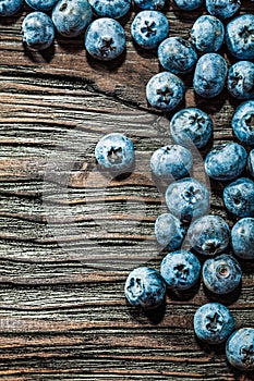 Heap of ripe bilberries on vintage wooden background