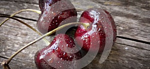 Heap of ripe juicy cherries on a wooden background