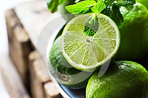 Heap of ripe organic limes cut in half in the sunlight, leaves o