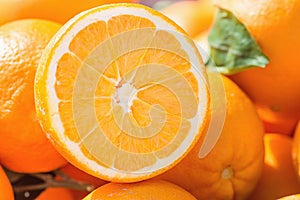 Heap of Ripe Organic Oranges at Farmers Market. One Fruit Cut in Half with Visible Texture Bright Vibrant Color. Vitamis Superfood