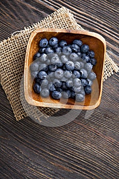 heap ripe sweet blueberries on wooden table top view