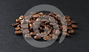 Heap of roasted coffee beans on black background
