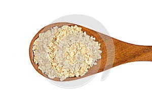 Heap of rolled oats with wooden spoon