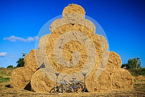 Heap of round straw bales with bycicle